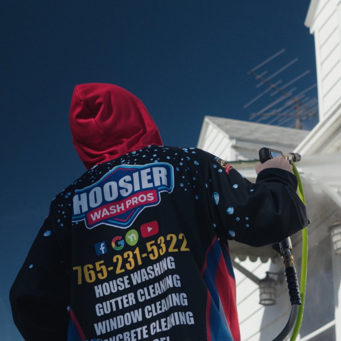Hoosier Wash Pros technician soft washing a home's siding